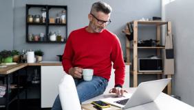 Homme assit sur son bureau qui pianote sur un ordinateur